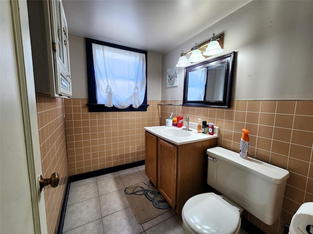 bathroom with tile patterned floors, toilet, vanity, and tile walls