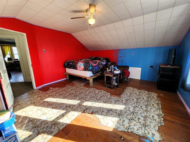 bedroom with ceiling fan, wood finished floors, and vaulted ceiling