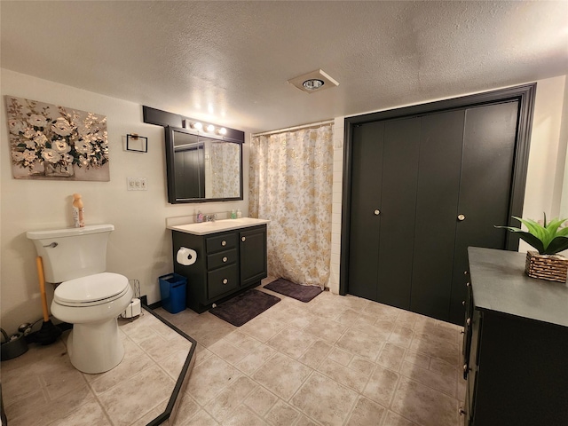 full bath with a textured ceiling, toilet, a shower with shower curtain, and vanity