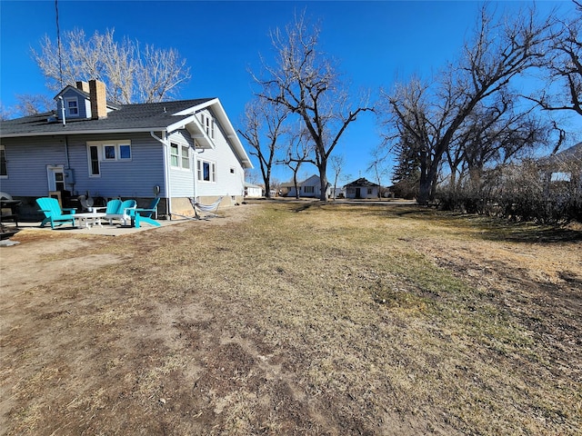 view of yard featuring an outdoor fire pit and a patio