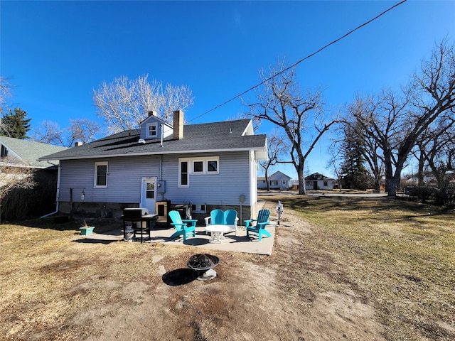 back of house with a patio, a chimney, a fire pit, and a lawn