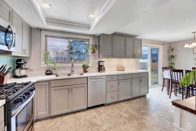 1565 Beaverhead Rd, Helena, MT 59602 - kitchen featuring appliances with stainless steel finishes, gray cabinetry, a sink, a tray ceiling, and light countertops
