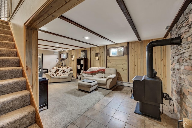 1565 Beaverhead Rd, Helena, MT 59602 - tiled living room featuring stairway, beamed ceiling, baseboard heating, wood walls, and a wood stove