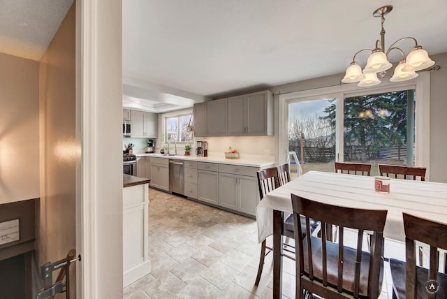 1565 Beaverhead Rd, Helena, MT 59602 - kitchen featuring gray cabinetry, stainless steel appliances, a sink, a chandelier, and stone finish flooring