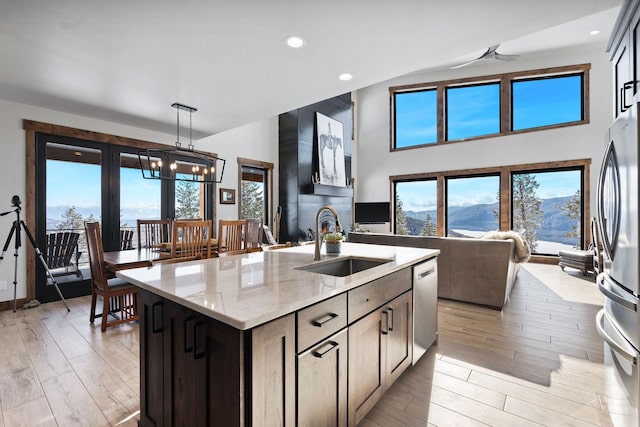 85 Meadows Dr, Whitefish, MT 59937 - kitchen with stainless steel appliances, open floor plan, light wood-type flooring, light stone counters, and recessed lighting