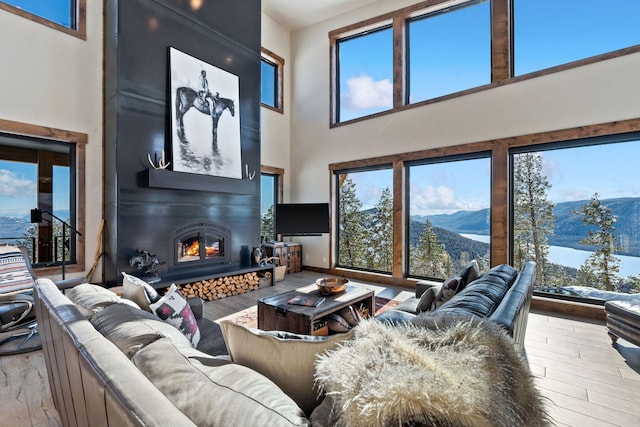85 Meadows Dr, Whitefish, MT 59937 - living room with a towering ceiling, a fireplace, a mountain view, and hardwood / wood-style flooring
