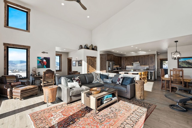 85 Meadows Dr, Whitefish, MT 59937 - living room featuring a high ceiling, ceiling fan, plenty of natural light, light wood finished floors, and a chandelier