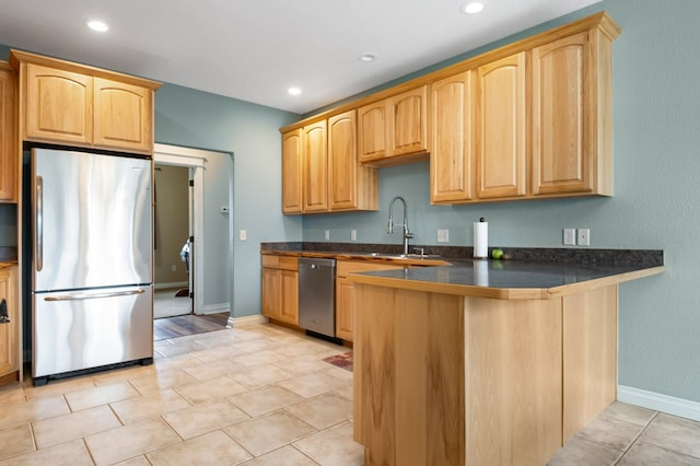 369 Gold Ct, Florence, MT 59833 - kitchen with stainless steel appliances, a sink, dark countertops, a peninsula, and baseboards