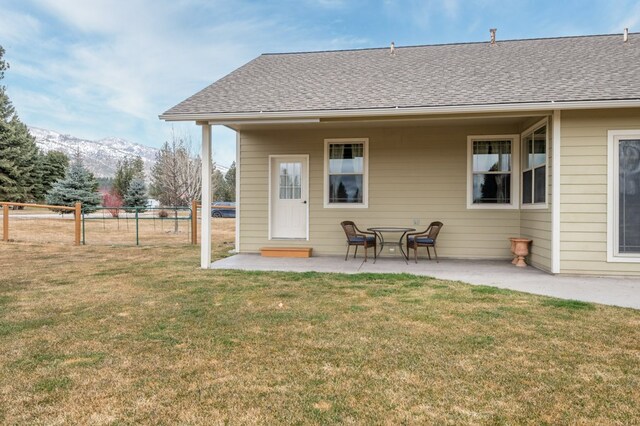 369 Gold Ct, Florence, MT 59833 - rear view of property featuring a mountain view, a patio area, and roof with shingles