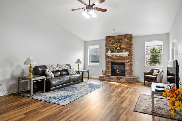 369 Gold Ct, Florence, MT 59833 - living area featuring a ceiling fan, healthy amount of natural light, wood finished floors, a stone fireplace, and vaulted ceiling