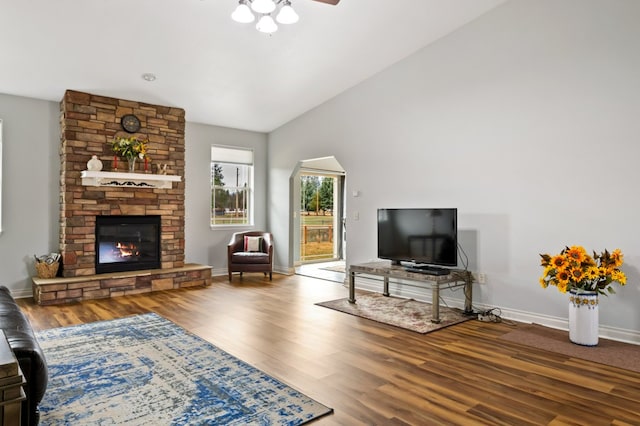 369 Gold Ct, Florence, MT 59833 - living room with wood finished floors, a stone fireplace, a ceiling fan, vaulted ceiling, and baseboards