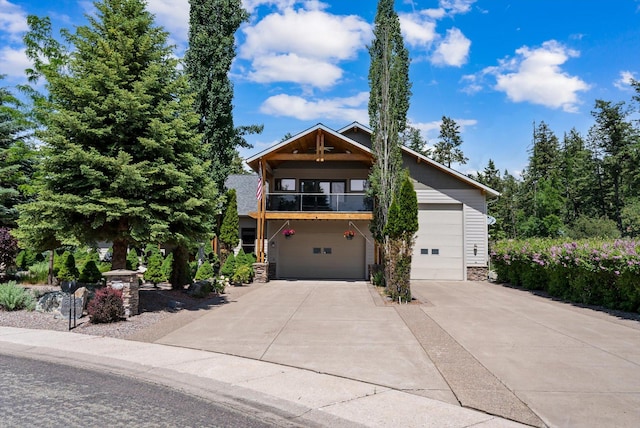 229AND231 Harbor Dr, Bigfork, MT 59911 - view of front of house featuring a balcony, driveway, stone siding, and an attached garage