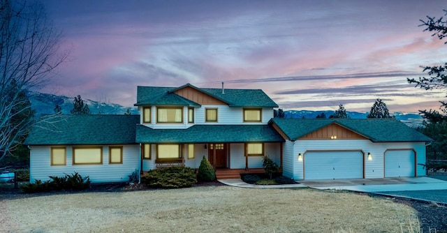 19066 King Rd, Florence, MT 59833 - view of front facade with concrete driveway, roof with shingles, a porch, a garage, and a yard