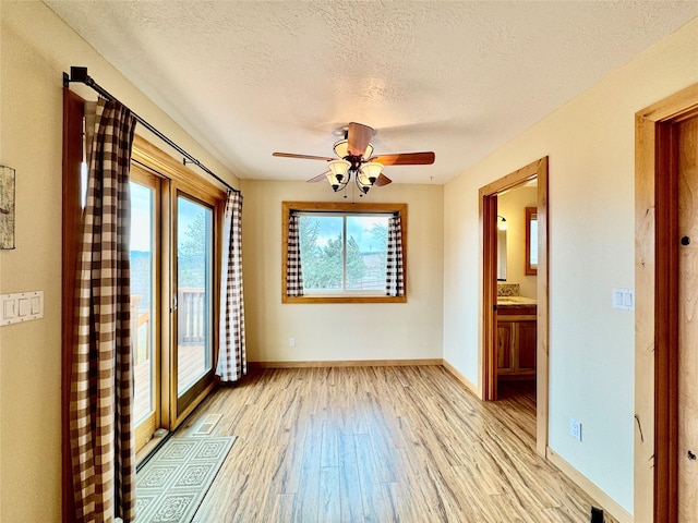 19066 King Rd, Florence, MT 59833 - empty room featuring plenty of natural light, light wood-style floors, a textured ceiling, and a ceiling fan