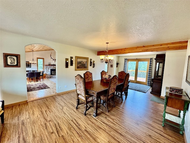 19066 King Rd, Florence, MT 59833 - dining area featuring arched walkways, baseboards, a notable chandelier, and light wood finished floors