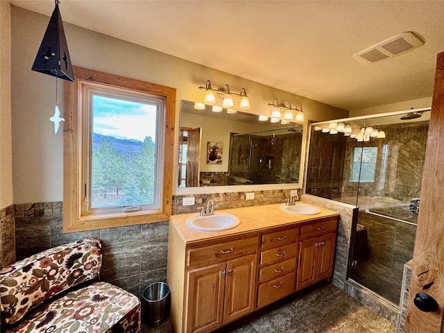 19066 King Rd, Florence, MT 59833 - bathroom with tile walls, visible vents, double vanity, and a sink