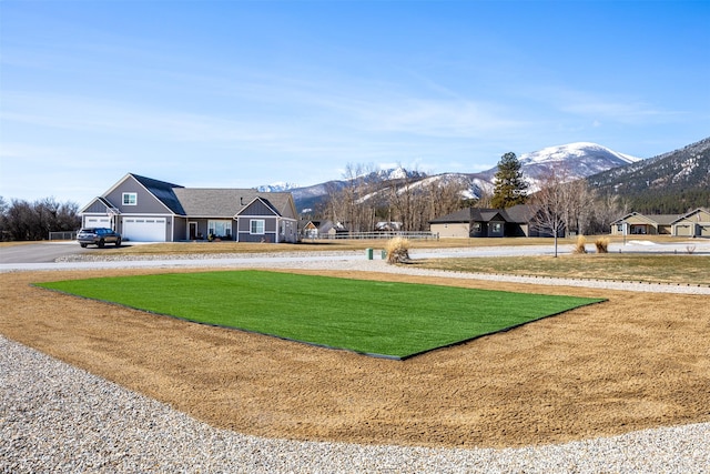 376 Cowboy Ct, Florence, MT 59833 - surrounding community with a mountain view, curved driveway, a yard, and an attached garage