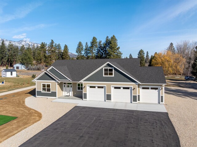 376 Cowboy Ct, Florence, MT 59833 - view of front of property with an attached garage, driveway, a mountain view, and a porch