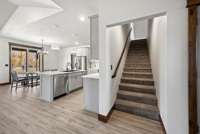 376 Cowboy Ct, Florence, MT 59833 - stairs featuring wood finished floors, a chandelier, and recessed lighting