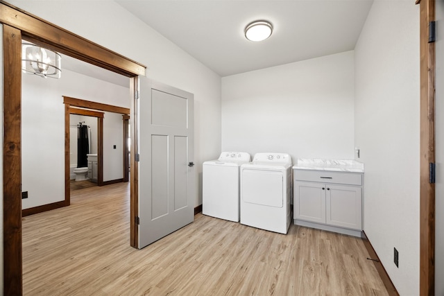 376 Cowboy Ct, Florence, MT 59833 - laundry room with cabinet space, light wood-type flooring, and washing machine and dryer