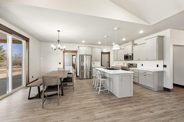 376 Cowboy Ct, Florence, MT 59833 - kitchen featuring stainless steel appliances, recessed lighting, lofted ceiling, a kitchen bar, and a chandelier
