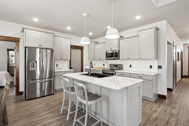 376 Cowboy Ct, Florence, MT 59833 - kitchen with stainless steel appliances, light wood-type flooring, tasteful backsplash, light stone countertops, and recessed lighting