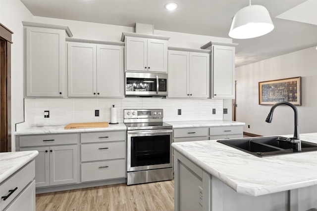 376 Cowboy Ct, Florence, MT 59833 - kitchen with appliances with stainless steel finishes, light wood-type flooring, tasteful backsplash, pendant lighting, and recessed lighting