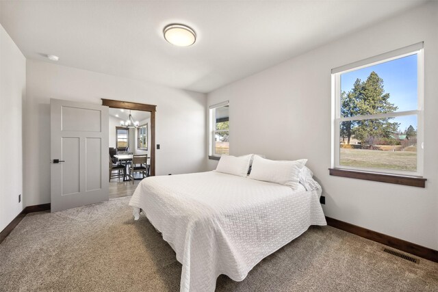 376 Cowboy Ct, Florence, MT 59833 - carpeted bedroom featuring multiple windows and a chandelier