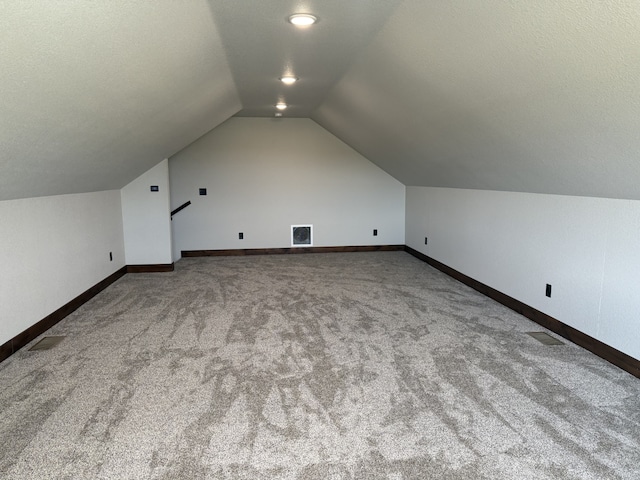 bonus room featuring lofted ceiling, baseboards, visible vents, and carpet