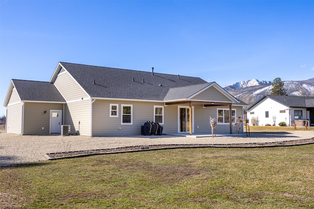 376 Cowboy Ct, Florence, MT 59833 - back of property with a yard, a mountain view, a patio, cooling unit, and a shingled roof