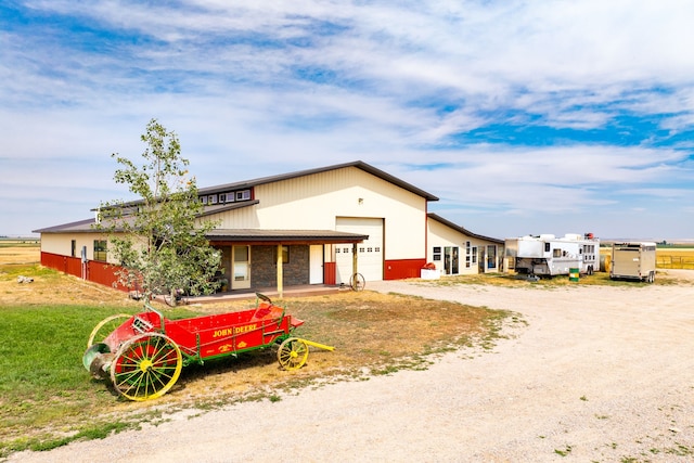 view of front of property featuring a garage and dirt driveway