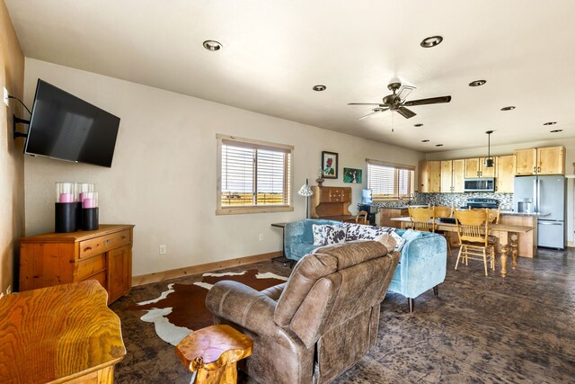 living room featuring baseboards, ceiling fan, and recessed lighting