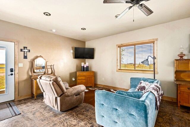 living room featuring baseboards and ceiling fan