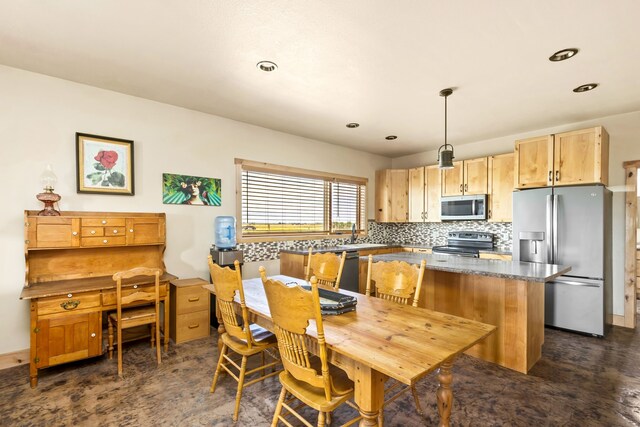 kitchen with tasteful backsplash, stainless steel appliances, light brown cabinetry, baseboards, and a kitchen island