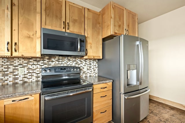 kitchen featuring baseboards, dark countertops, tasteful backsplash, and appliances with stainless steel finishes