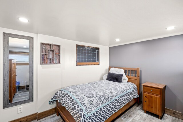 bedroom with baseboards, wood finished floors, and recessed lighting