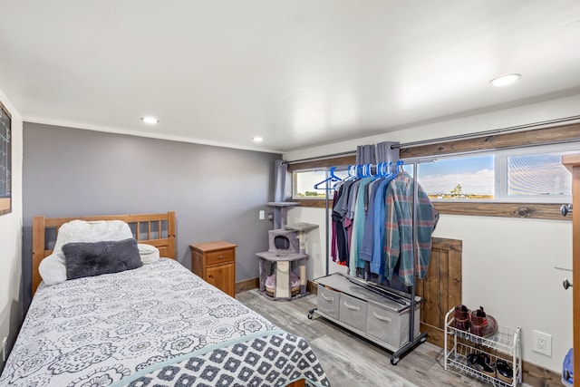 bedroom featuring baseboards, wood finished floors, and recessed lighting