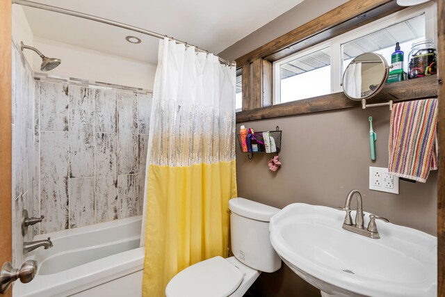 full bathroom with toilet, a sink, and shower / bath combo with shower curtain