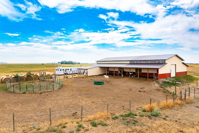 back of property with an exterior structure, an outdoor structure, and a rural view