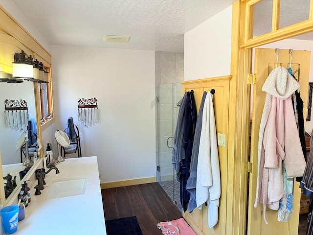 675 Bobcat Ln, Hamilton, MT 59840 - full bath with vanity, a textured ceiling, baseboards, wood finished floors, and a stall shower