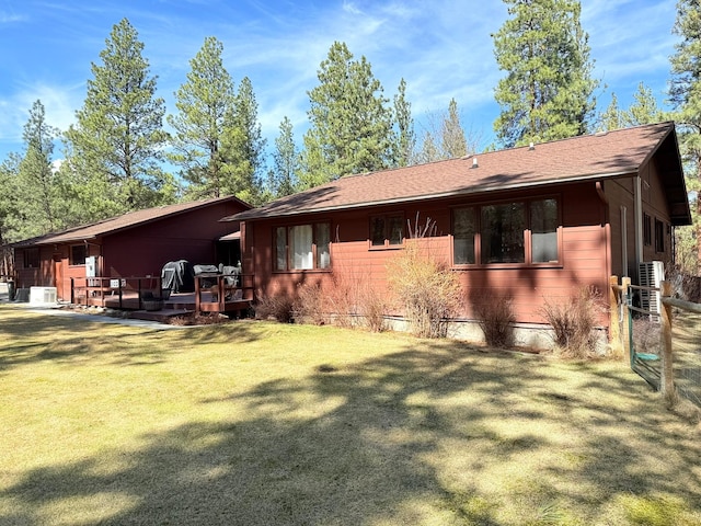 675 Bobcat Ln, Hamilton, MT 59840 - back of house featuring a lawn, a deck, cooling unit, and a shingled roof