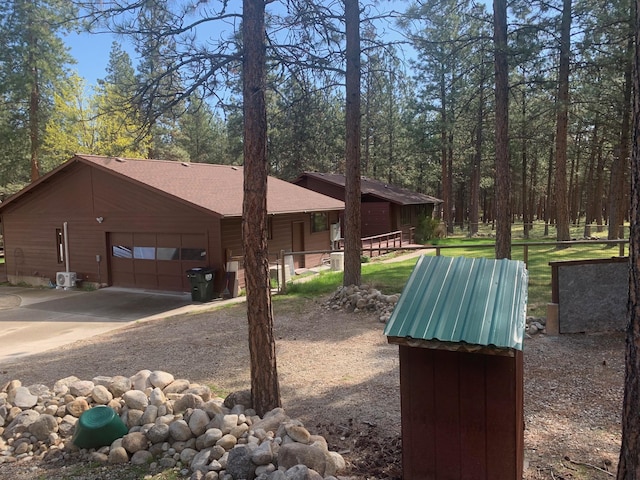 675 Bobcat Ln, Hamilton, MT 59840 - view of side of home featuring an attached garage, driveway, and roof with shingles