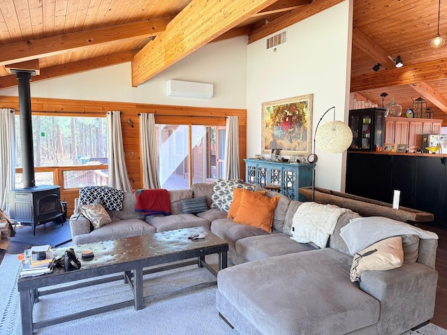 675 Bobcat Ln, Hamilton, MT 59840 - living room featuring visible vents, a wood stove, beamed ceiling, a wall unit AC, and wooden ceiling
