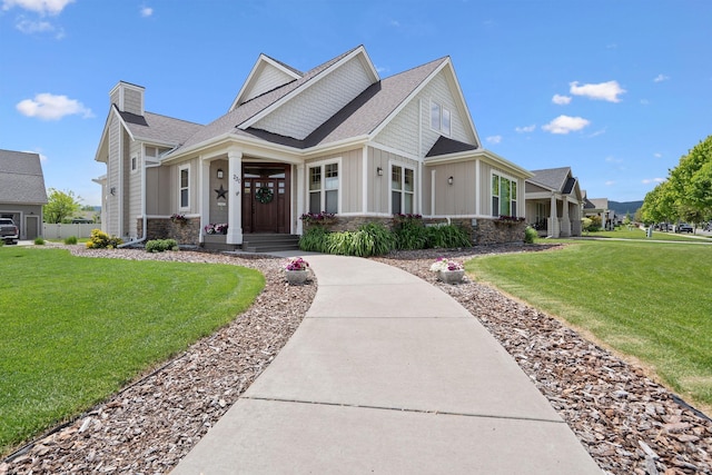 230 Camp Crook Ave, Kalispell, MT 59901 - view of front of property featuring stone siding, board and batten siding, roof with shingles, and a front lawn