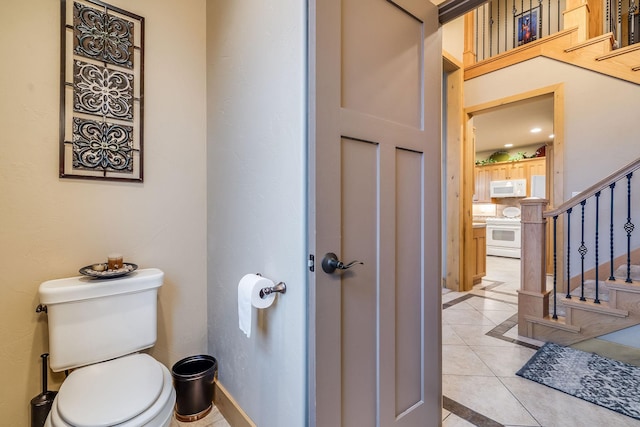 bathroom with tile patterned flooring, toilet, baseboards, and recessed lighting