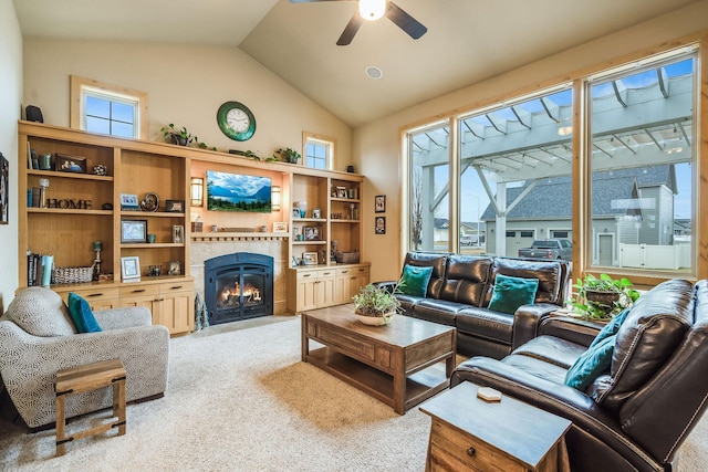 living area featuring lofted ceiling, ceiling fan, a tiled fireplace, and light carpet