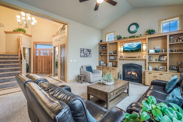 living room with stairway, light colored carpet, high vaulted ceiling, ceiling fan with notable chandelier, and a fireplace