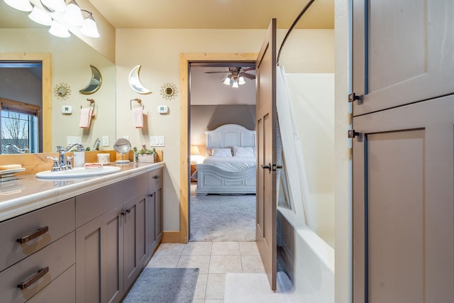 ensuite bathroom featuring ensuite bathroom, ceiling fan, vanity, shower / bathtub combination with curtain, and tile patterned flooring