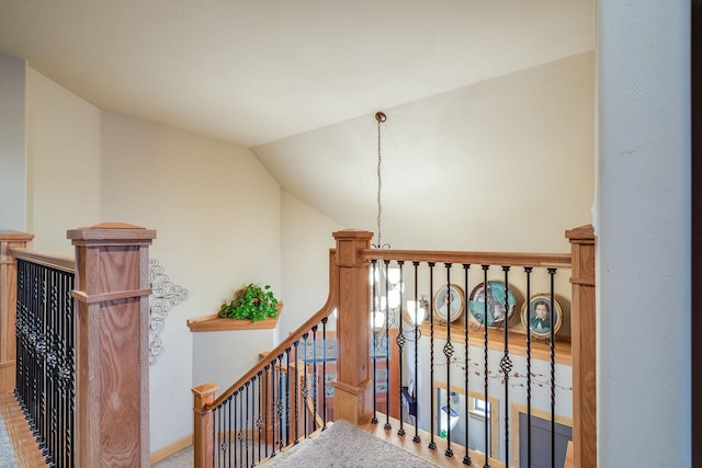 stairway featuring baseboards and lofted ceiling