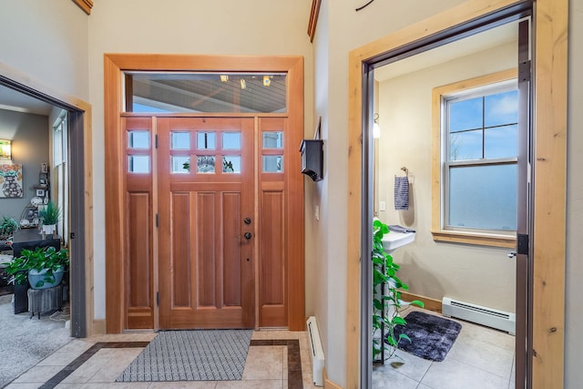 tiled entryway featuring a baseboard radiator and baseboards
